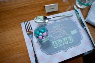 Table setting: personalized placemat with celebrant's bits of info., place cards.